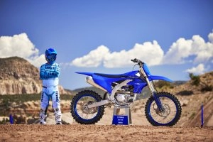 YZ450F Team Yamaha Blue on stand with rider next to it}
